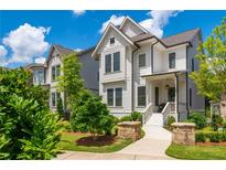 Charming two-story home with white siding, a landscaped yard, and inviting front porch at 720 Tannery Cmn, Alpharetta, GA 30009