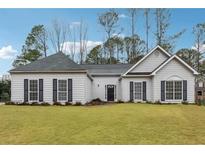 Charming single-story home featuring a well-manicured lawn and inviting entrance at 2006 Hawthorne Way, Woodstock, GA 30189