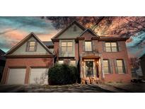 Charming two-story brick home features an attached two-car garage, shuttered windows, and mature landscaping at 4074 Gold Mill Rdg, Canton, GA 30114