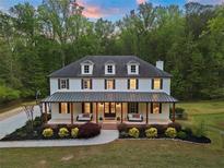 Charming two-story home with a covered porch, swing benches, manicured landscaping and a welcoming entrance at 650 Jones Rd, Roswell, GA 30075
