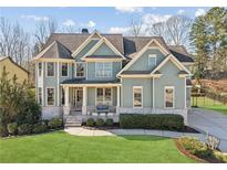 Charming two-story home with a manicured front yard and inviting covered porch with seating area at 2952 Perimeter Cir, Buford, GA 30519