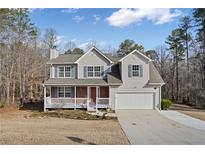 Charming two-story home with a well-manicured front lawn and attached two car garage at 1509 Sierra Ridge Pl, Loganville, GA 30052