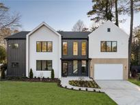 Modern home showcasing a well-manicured lawn, contrasting dark and white exterior, and a two-car garage at 198 Johnson Ferry Nw Rd, Atlanta, GA 30328