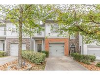 Charming townhouse featuring a well-maintained lawn and an attached single-car garage at 469 Tufton Se Trl, Atlanta, GA 30354