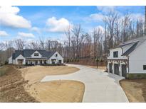 Beautiful white farmhouse with a three car garage and long driveway at 8710 Little Mill Rd, Cumming, GA 30041