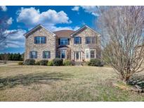 Beautiful brick two-story home with a well-manicured front yard and mature trees at 85 Tanglewood Dr, Covington, GA 30016