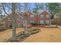 Charming brick home with manicured front yard and inviting water feature at 2329 Crestknoll Cir, Decatur, GA 30032