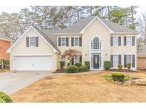 Charming two-story home featuring a well-manicured lawn and attached two car garage at 717 Southland Pass, Stone Mountain, GA 30087