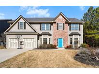 Charming two-story home featuring a blue front door, two-car garage, and landscaped front yard at 87 Canvasback Way, Hiram, GA 30141