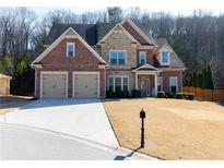 Beautiful brick and stone two-story home with an attached two-car garage and well-manicured lawn at 1960 Overlook Springs Ln, Cumming, GA 30040