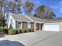 Charming home with a brick and siding exterior, complemented by a well-maintained lawn and an attached two-car garage at 2357 Barrett Cottage Pl, Marietta, GA 30066