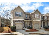 Charming townhome featuring a one-car garage, stone accents, and a cozy front porch, nestled in a well-maintained community at 3343 Blue Springs Nw Walk, Kennesaw, GA 30144