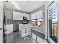Modern kitchen featuring stainless steel appliances, a kitchen island with seating, and a window with city views at 898 Oak Sw St # 1306, Atlanta, GA 30310