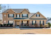 Charming brick two-story home with a welcoming front porch and manicured landscaping at 4220 Lindsey Way, Conyers, GA 30013