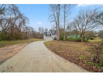 View of the home's exterior, front lawn, long driveway and some winter landscaping at 6112 Shadow Rock Ln, Lithonia, GA 30058