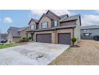 Two-story home featuring a brick and siding exterior, attached two-car garage and concrete driveway at 1160 Faulkner Way, Jonesboro, GA 30238