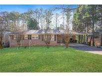Charming brick home featuring a lush green lawn and mature trees, enhancing its curb appeal at 4183 Hideaway Dr, Tucker, GA 30084