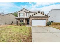Charming two-story home with brick accents, a two-car garage, and a well-maintained front yard at 450 Lake Ridge Ln, Fairburn, GA 30213