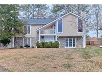 Two-story home with a stone foundation, upper balcony and large picture windows at 1370 Dellinger Ct, Marietta, GA 30062