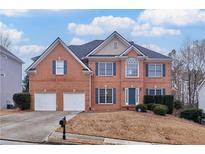 Traditional brick home featuring a two-car garage, manicured lawn, and inviting front entrance at 4305 Riverglen Cir, Suwanee, GA 30024