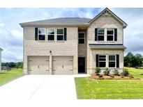 Two-story brick home featuring a two-car garage, lush lawn, and dark shutters at 642 Egrets Landing #66, Covington, GA 30014