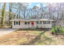 Charming one-story home with a red front door and a well-maintained lawn at 3192 Belfort Se Rd, Atlanta, GA 30354