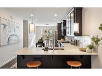 Modern kitchen features stainless steel appliances, a breakfast bar, and pendant lighting at 754 Aerial Way, Atlanta, GA 30312