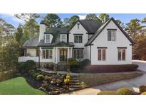 Charming two-story painted brick home featuring a landscaped yard and covered porch at 135 Newcastle Ct, Roswell, GA 30076