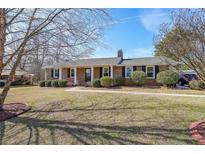 Charming single-story brick home featuring manicured landscaping and a welcoming front entrance at 3908 Summit Dr, Douglasville, GA 30135