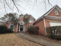 Charming brick home featuring a well-manicured lawn and an attached two car garage at 914 Georgian Point Dr, Lawrenceville, GA 30045