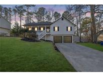 Charming home features a well-manicured lawn and inviting front porch at 8065 Sumit Wood Nw Dr, Kennesaw, GA 30152