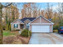 Charming one-story home featuring a two-car garage, stone accents, and a well-manicured front yard at 3434 Saddlebrook Dr, Loganville, GA 30052