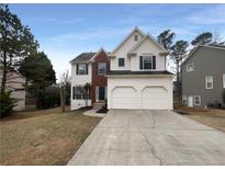 Charming two-story home with brick and white siding, a two-car garage and mature landscaping at 4226 Glenlake Nw Pkwy, Kennesaw, GA 30144