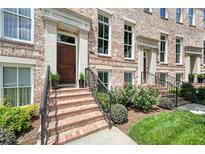 Charming brick townhome featuring a stately wood door, elegant landscaping and wrought iron railings at 222 Inman Ne Ln, Atlanta, GA 30307