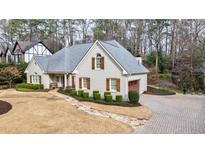 Charming home with stone walkway, brick driveway, and a well-manicured front lawn at 630 Denards Se Ml, Marietta, GA 30067