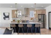 Modern kitchen with stainless steel appliances, a large island, stylish stools, and wooden cabinets at 1273 Danner Se St, Atlanta, GA 30316
