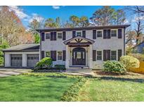 Charming two-story home with a brick facade, shutters and a well manicured lawn at 1615 Arden Sw Dr, Marietta, GA 30008