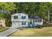 Charming two-story home with blue shutters, lush trees, and a well-maintained lawn at 2010 Smith Nw Dr, Kennesaw, GA 30144