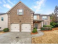 Charming brick home with a two-car garage and well-maintained landscaping at 2100 Trinity Mill Dr, Dacula, GA 30019