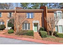 Charming brick townhome with a well-manicured front yard and a pop of color from the painted front door at 3454 Ashwood Ln, Atlanta, GA 30341