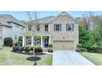 Charming brick two-story home with manicured landscaping and a two-car garage at 6845 Rocking Horse Ln, Cumming, GA 30040