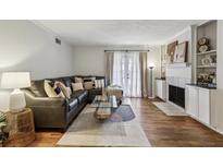 Inviting living room featuring a plush sectional sofa, glass coffee table, and stylish fireplace with built-ins at 1150 Collier Nw Rd # C10, Atlanta, GA 30318