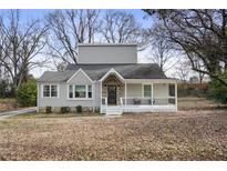 Charming grey two-story home featuring a welcoming front porch and mature trees at 1916 Cannon St, Decatur, GA 30032