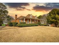Charming brick home with inviting front porch and meticulously maintained landscaping at 5770 Wyndemere Ln, Stone Mountain, GA 30087