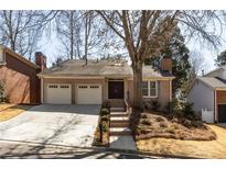Charming brick home featuring a two-car garage and meticulously maintained landscaping at 1205 Club Walk Ne Dr, Brookhaven, GA 30319