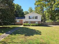 Charming two-story home with a well-maintained lawn and mature trees at 137 Bonnie Nw Ln, Lilburn, GA 30047