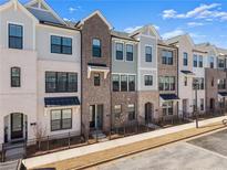 Attractive townhome exteriors showcasing varied brick and siding, accented by black window frames and awnings at 355 Walker Ave, Roswell, GA 30076