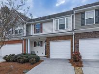 Two-story townhome featuring a stone facade, neutral siding, and a two-car garage at 319 Franklin Ln, Acworth, GA 30102