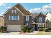 Charming two-story home with a well-manicured front yard and brick and stone facade at 1309 Avington Glen Dr, Lawrenceville, GA 30045