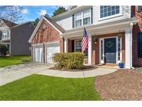Charming home featuring a brick facade, a two-car garage and a well-manicured lawn at 5815 Buckner Creek Dr, Mableton, GA 30126